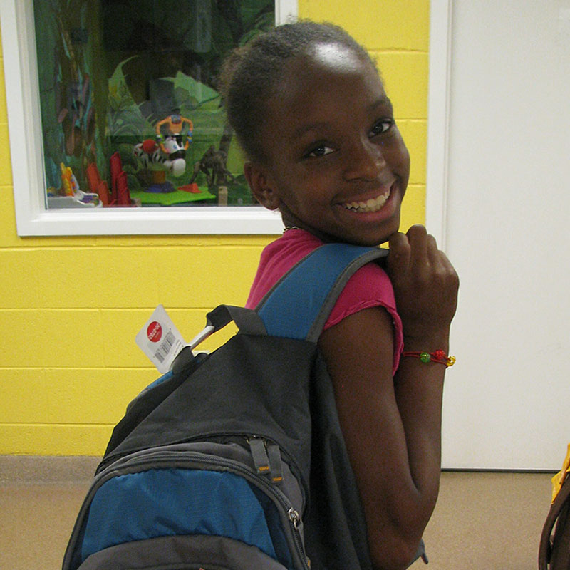 Girl with backpack full of school supplies
